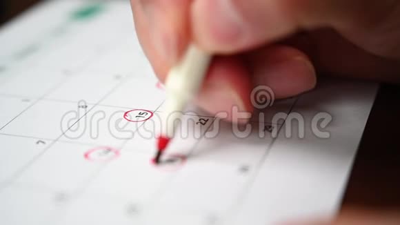 慢动作一个人手里拿着一支笔把他的日程记录在桌历上视频的预览图