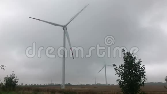 多云天空背景下的风力涡轮增压农业领域生产清洁可再生能源的风力涡轮机视频的预览图
