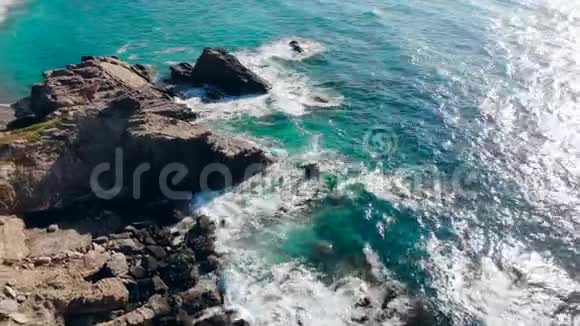 蓝色的大海拍打着岩石海岸视频的预览图