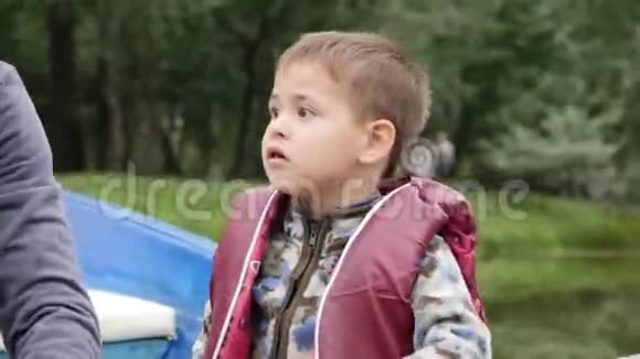 小可爱的孩子在湖边公园里度过时光的肖像快乐的小男孩坐在船上环顾四周快关门视频的预览图