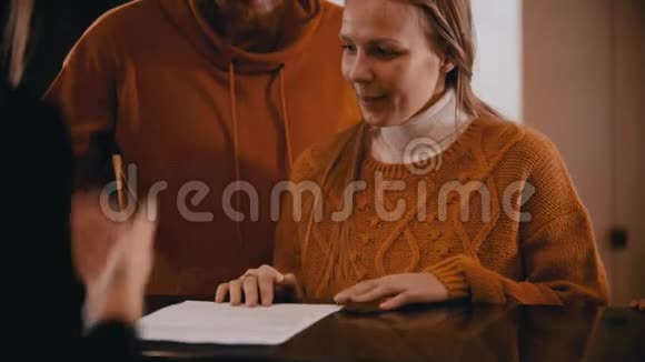 一家人在豪华酒店登记一个微笑的女人在文件上签名视频的预览图