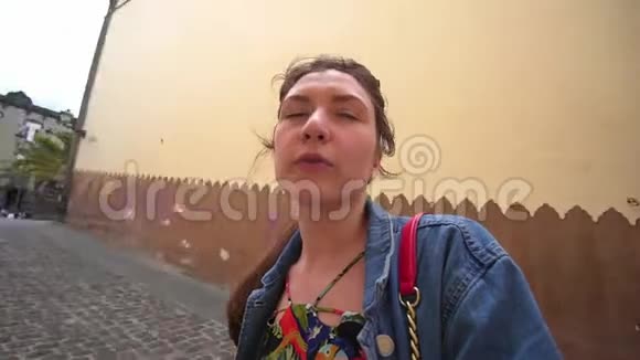一位年轻的白人女性博客作者在dslr摄像机上拍摄自己的视频并讲述了第一人称的旅程视频的预览图