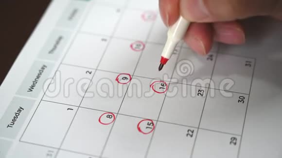 一个人手里拿着一支笔把他的日程记录在桌历上的手视频的预览图