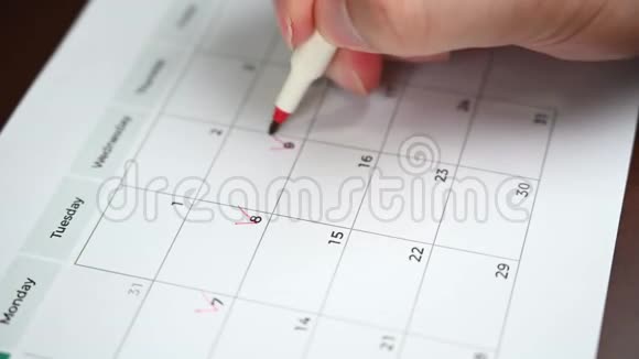 一个人手里拿着一支笔把他的日程记录在桌历上的手视频的预览图