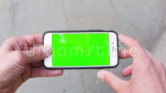 一个高加索人使用绿色屏幕铬键智能手机放松的个人视角视频的预览图