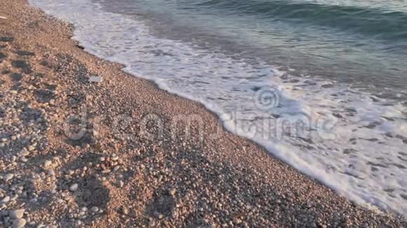 海岸线关闭海浪缓慢地冲上岸日落日出时的卵石海滩亚得里亚海视频的预览图