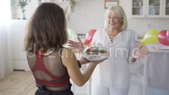 女儿祝妈妈生日快乐给她巧克力蛋糕女人拥抱和微笑生日庆典视频的预览图
