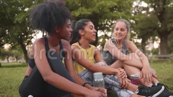一群笑容可掬的女性朋友坐在一起在公园里愉快地交谈视频的预览图