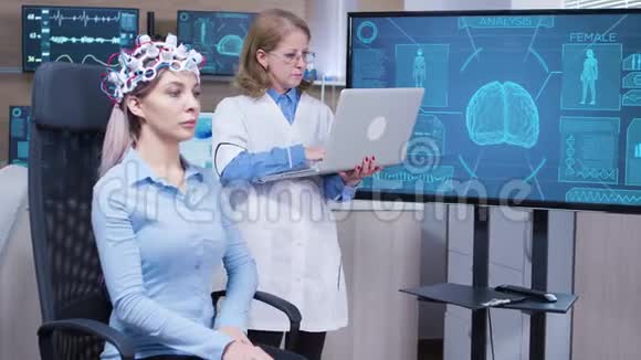 神经科学女医生检查她笔记本电脑上的脑部数据视频的预览图