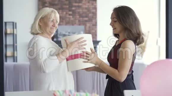 女儿祝妈妈生日快乐并给她的礼物盒里有内衣女人拥抱和微笑视频的预览图