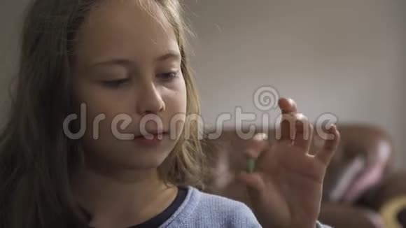 一个生病的白种人女孩的特写脸吞下一片绿色的草药药丸坐在家里微笑孩子有视频的预览图
