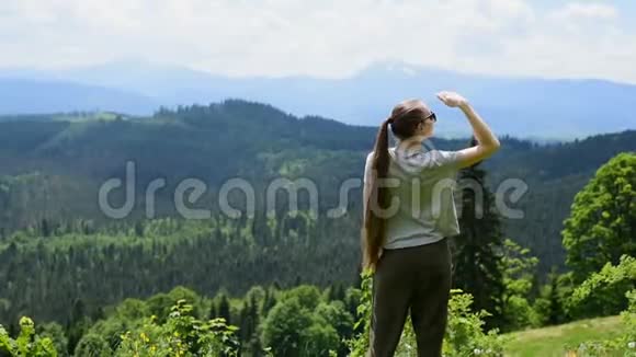 美丽的女孩站着远远地看着青山绿水日光灯视频的预览图