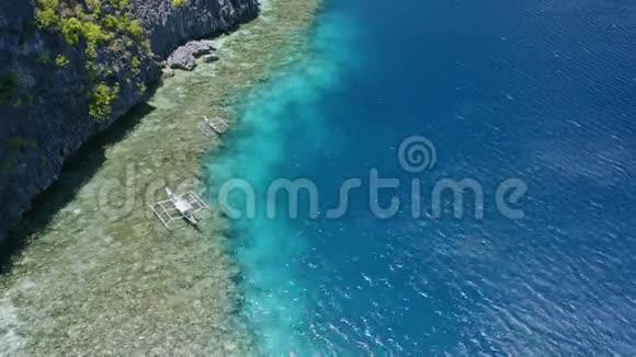 banca旅游船停泊在珊瑚礁边缘的空中镜头菲律宾巴拉望视频的预览图