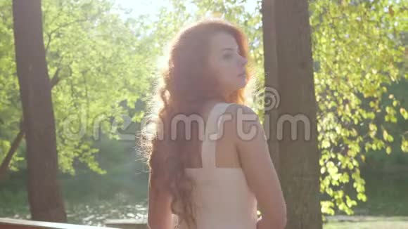 漂亮的红头发体贴的女人转过身来看着远处年轻的白种人女孩沐浴在阳光下视频的预览图