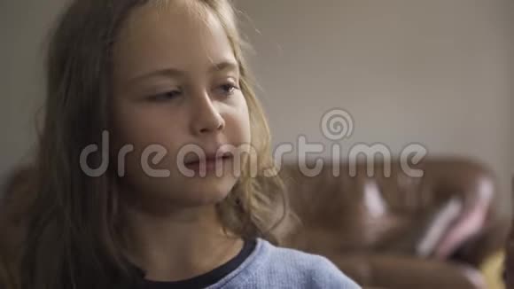 穿着蓝色毛衣戴着绿色药丸的白种人小女孩的特写镜头一名白人儿童视频的预览图