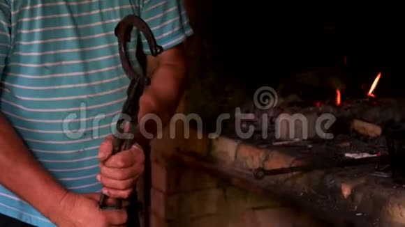 铁匠用钳子拿着热马蹄铁视频的预览图
