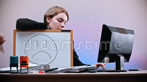 一个办公室在工作一个男人带着悲伤的微笑来到一个女人面前擦去标志画着微笑视频的预览图