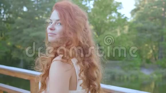 令人难以置信的迷人的白种人女人红色的头发转过身来看着镜头微笑天然肥料视频的预览图