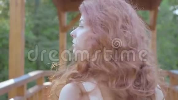 美丽的苗条女人红色的头发走在桥上然后转身看着相机户外休闲女孩视频的预览图