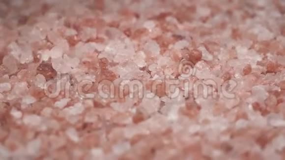 旋转喜玛拉雅盐的宏观镜头并落在桌子上粉红色的盐很好吃很好的香料视频的预览图