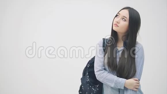 年轻的亚洲女孩肩上背着背包打电话给某人但联系不到他藏着电话看着愤怒和愤怒视频的预览图