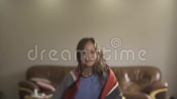 快乐的白种人女孩披着温暖的披肩在房间里转悠这个女孩病后康复了概念视频的预览图