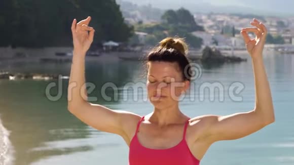 运动成年女子在海边练习泥沼瑜伽视频的预览图