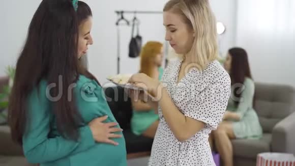 两个有魅力的白种人孕妇吃糖果抚摸他们的肚子准女人和她的朋友视频的预览图