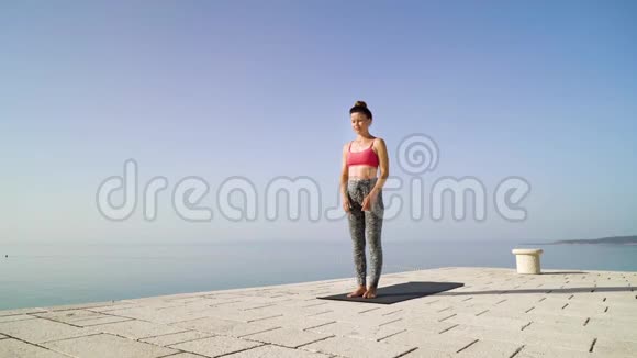 运动健身女孩在海上码头练习瑜伽视频的预览图