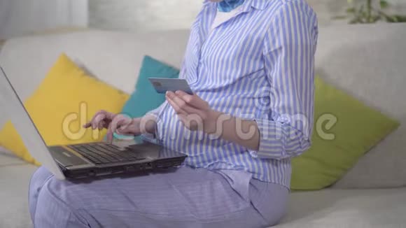 无法辨认的年轻孕妇使用笔记本电脑和银行卡视频的预览图