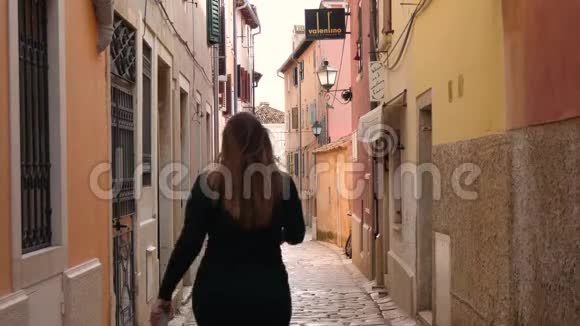 在Rovinj市狭窄的街道上行走的女性视频的预览图