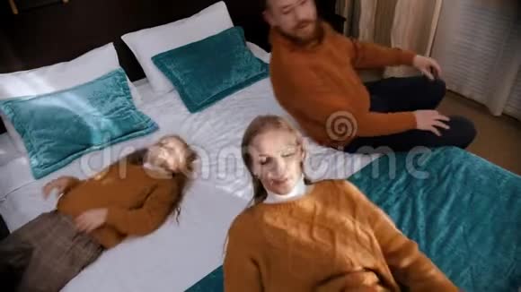旅途愉快的一家人倒在旅馆的床上视频的预览图