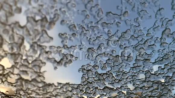 湿冰落在汽车的湿玻璃上雪花流下来视频的预览图