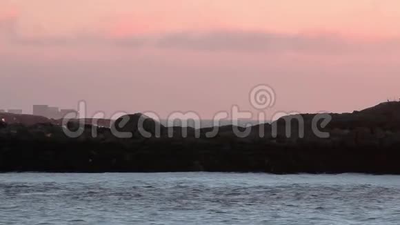 粉红天空上的一艘集装箱船在黎明时分驶进爱尔兰海视频的预览图
