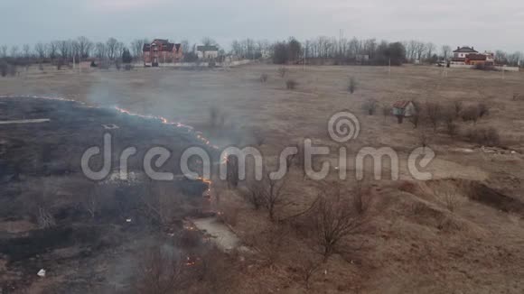 生态问题一个村庄在燃烧的田野上烟雾蔓延到田野和火燃烧着干燥的土地视频的预览图