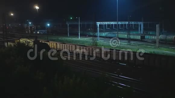 有空车的货运列车夜间在车站行驶视频的预览图