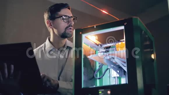 工作人员用笔记本电脑控制3D打印机工程师与3D打印机在一个设计工作室视频的预览图