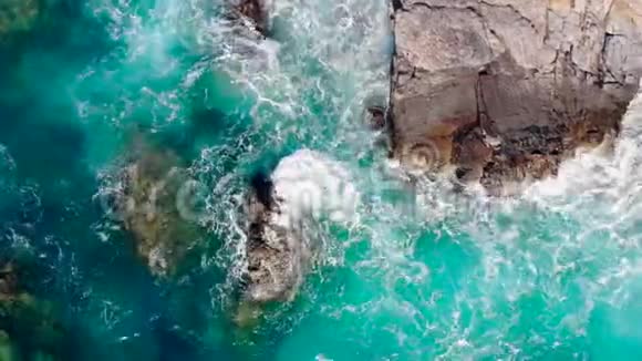 蓝色的波浪拍打着岸边的悬崖视频的预览图