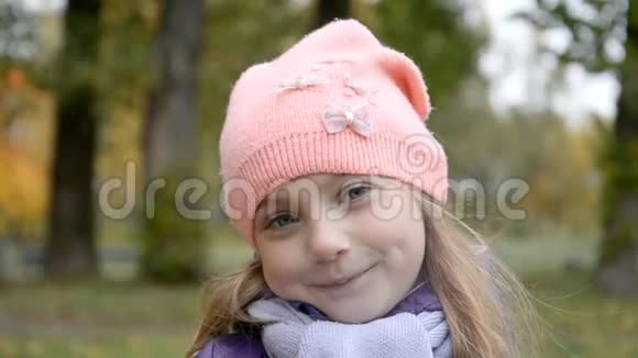 一个戴着粉红色帽子的五岁女孩的肖像看着镜头脸上带着微笑视频的预览图