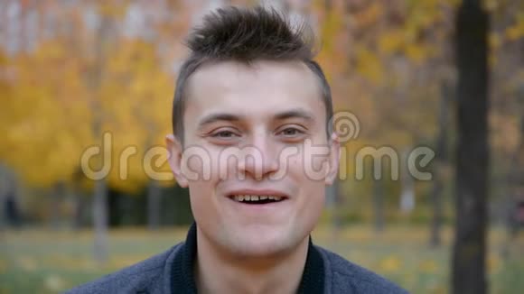 在秋季公园摆姿势拍照的年轻帅哥快乐健康的生活理念视频的预览图