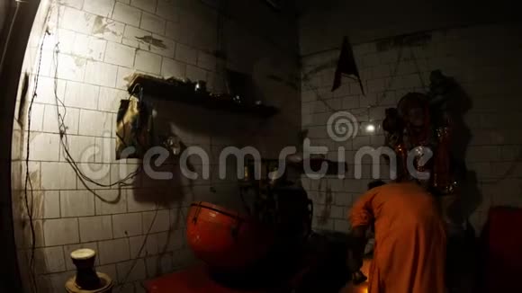 印度教晚会自动阿提机播放和尚穿橙色衣服铃声和灯大灯芯雕像视频的预览图