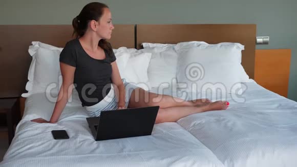 有笔记本电脑的女人在床上放松视频的预览图