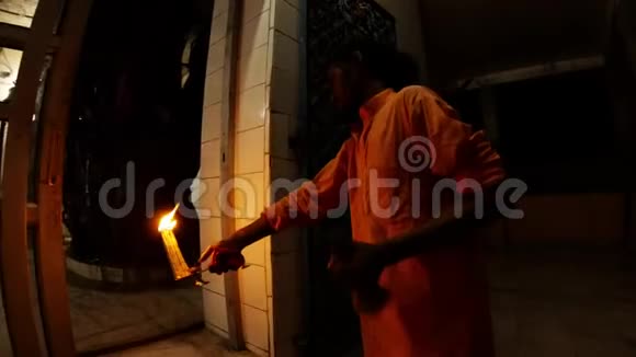 年轻的印度僧人在庙夜的夜晚在黑暗的夜晚用燃烧的灯具在走廊前反复做动作视频的预览图
