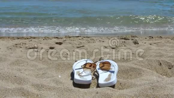 女性拖鞋和太阳镜在海边的沙滩上视频的预览图