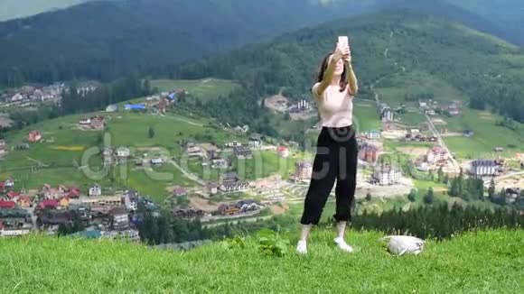 美丽的黑发女孩在山上背景下自拍白天视频的预览图