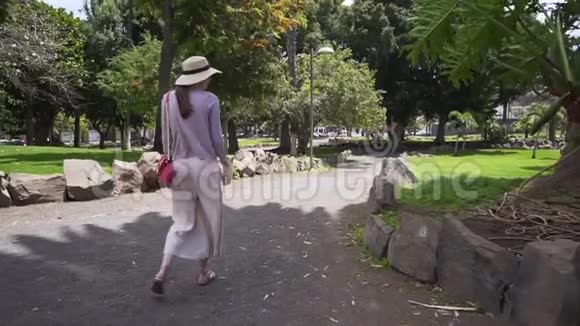 时尚女孩游客在一个美丽的西班牙公园散步孤独的女人在度假西班牙特内里费视频的预览图