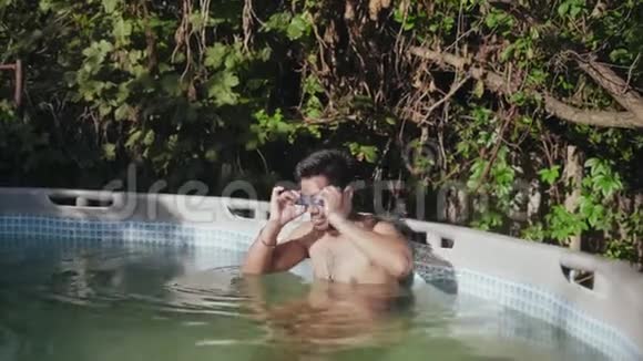 穿着游泳衣穿着潜水护目镜和游泳裤的印度男人儿童游泳池视频的预览图
