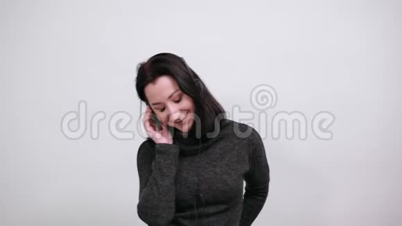 穿着休闲黑色毛衣的白种人女人听音乐闲逛举手视频的预览图