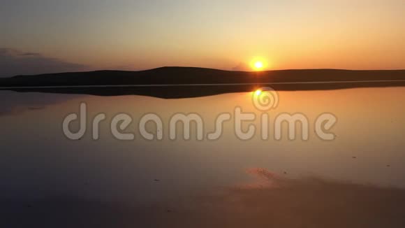 克里米亚美丽的粉红色矿物湖鸟瞰乘着夕阳飞过咸咸的科亚什斯基湖视频的预览图