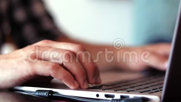 近距离拍摄男人手在笔记本电脑上打字视频的预览图